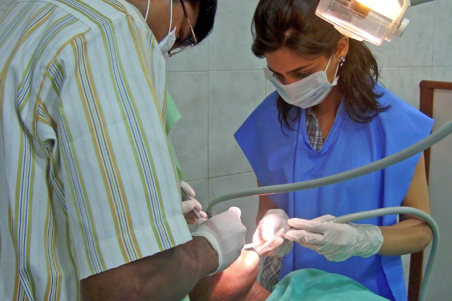 Two dentists performing a procedure on a patient in a clinic.