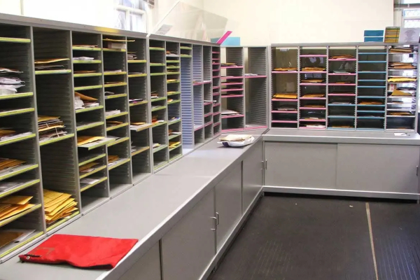 A mailroom with shelves containing mails and files.